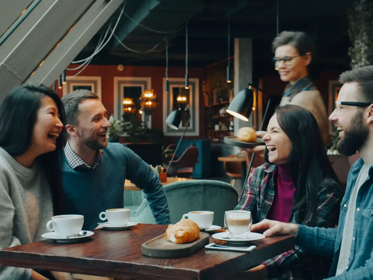 Friends laughing over coffee in a café