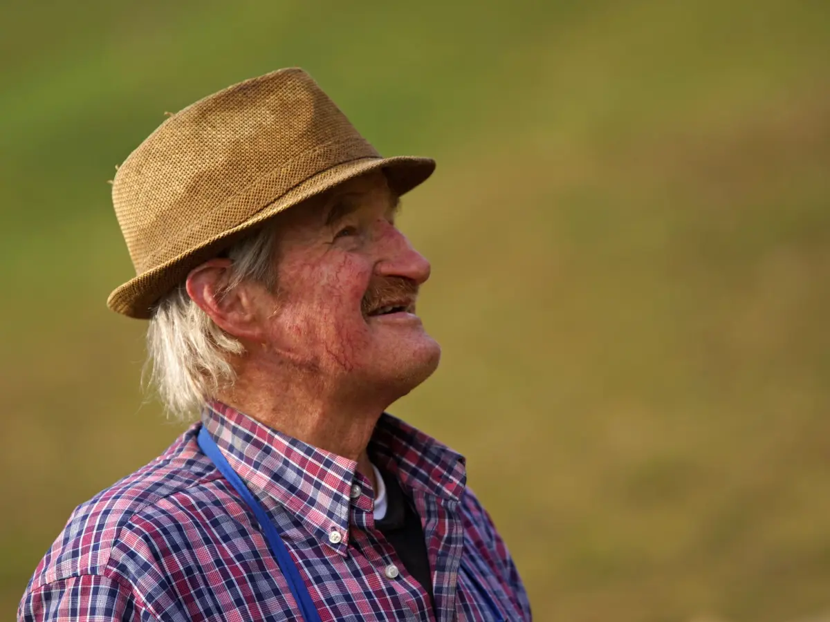 A farmer in a straw hat smiling in his field