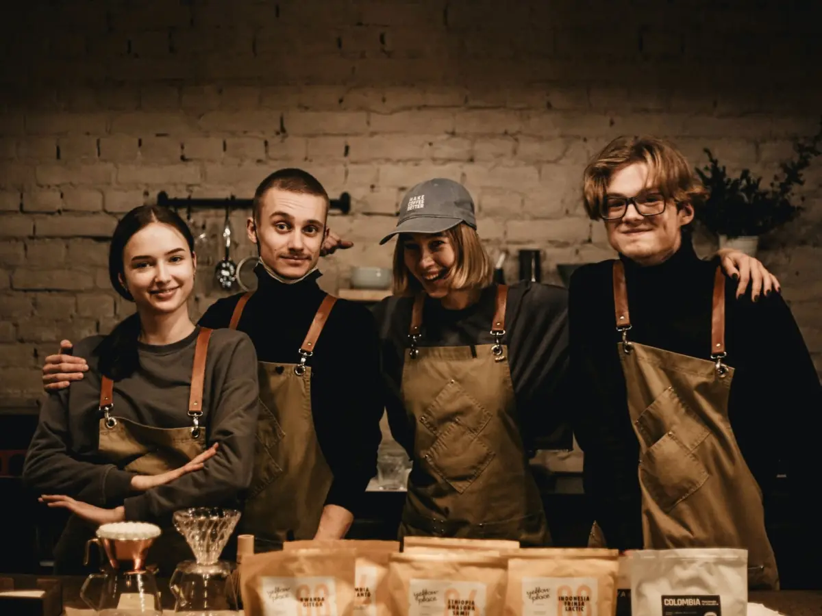 A café team in aprons standing together behind the counter